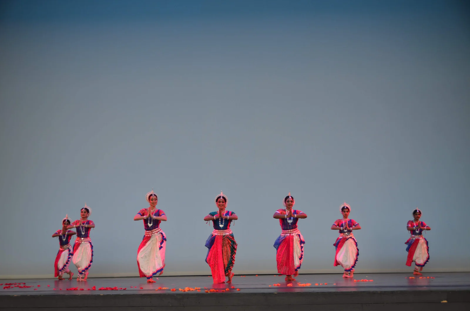 Odissi dancers in traditional attire, mid-performance with expressive hands and eyes