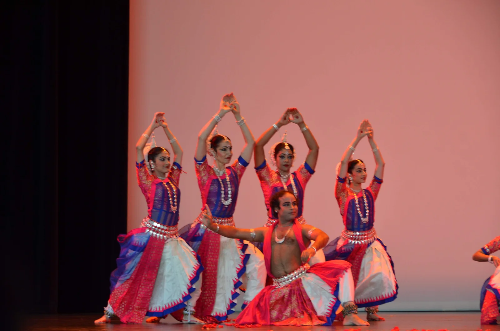 Odissi dancers in traditional attire striking an elegant pose with their hands framed