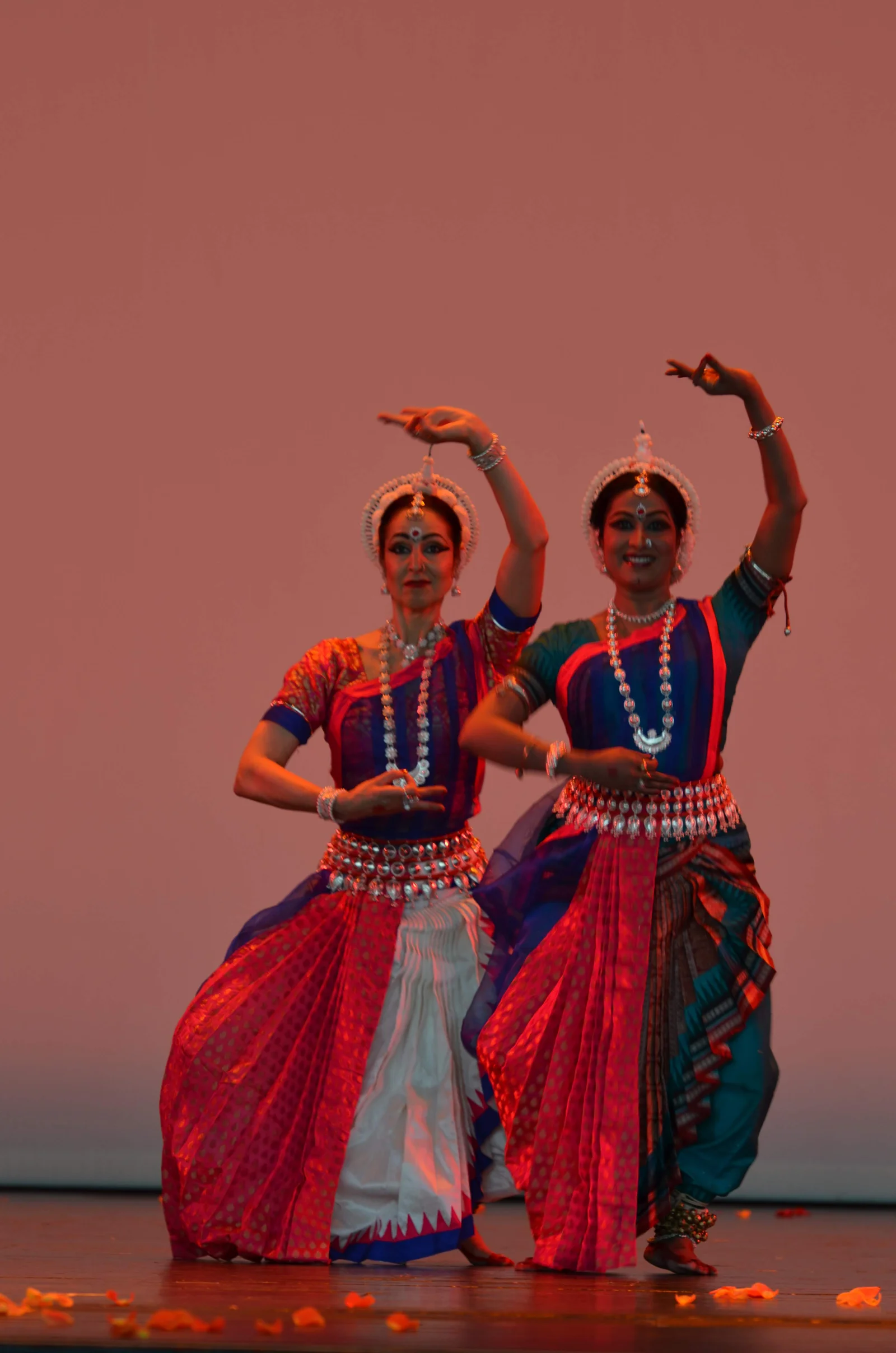 Odissi dancer in traditional attire striking a graceful pose with intricate jewelry and vibrant costume.