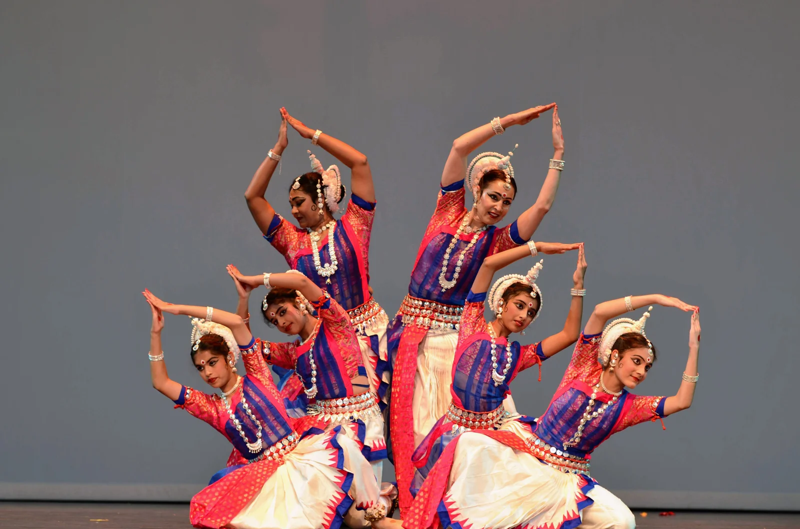 Odissi dancers in traditional attire performing a synchronized dance