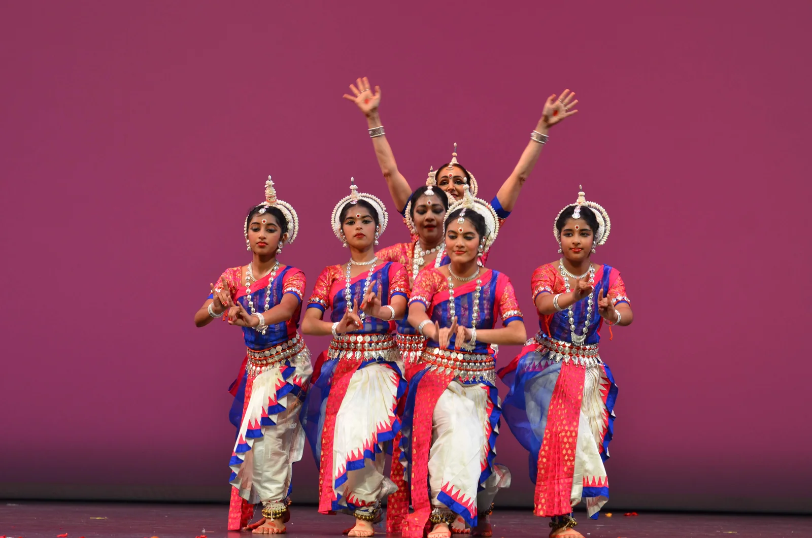 Odissi dancers in traditional costumes performing synchronized movements