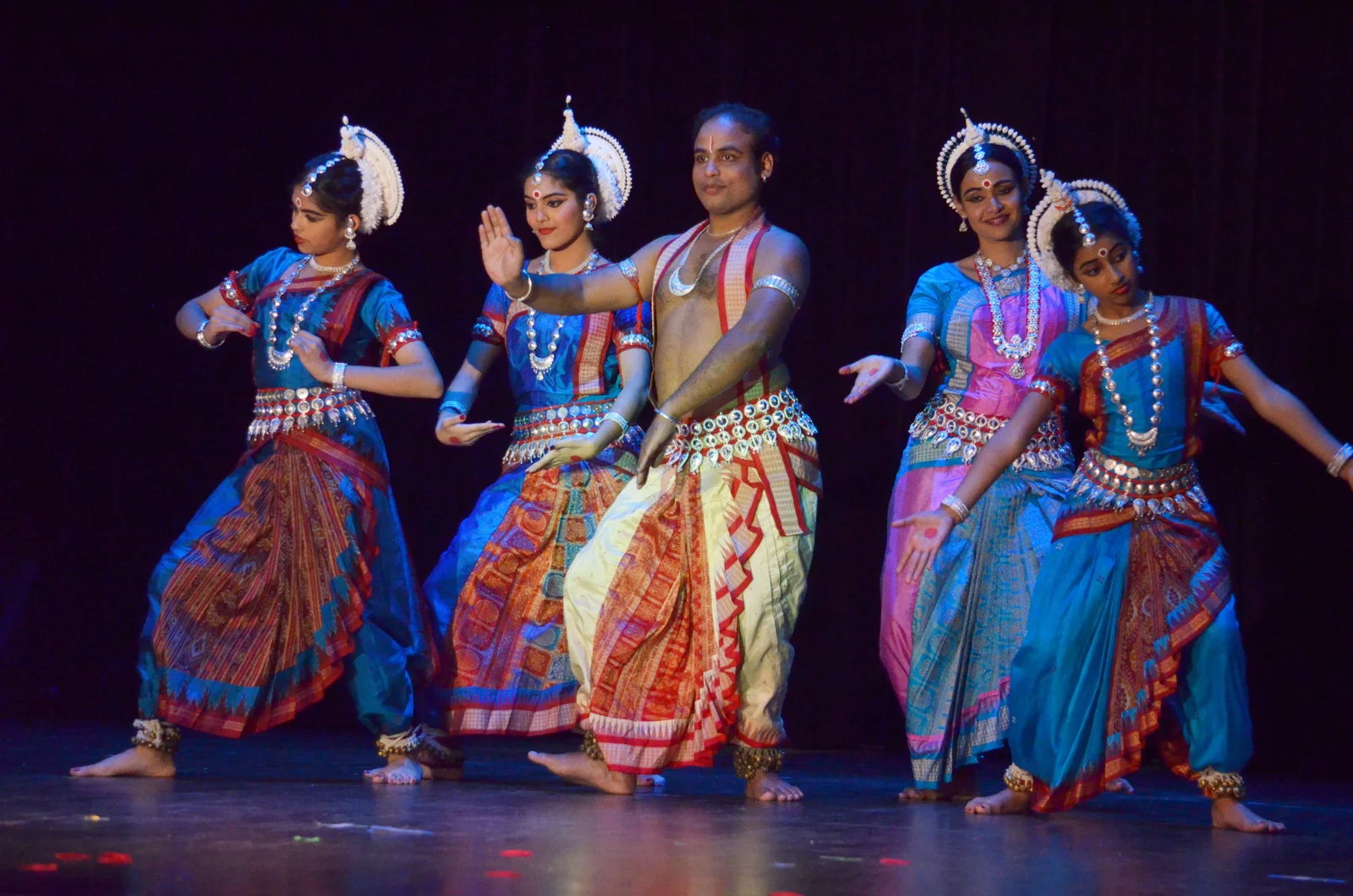 Odissi dancers performing with their guru on a beautifully adorned stage in Austin