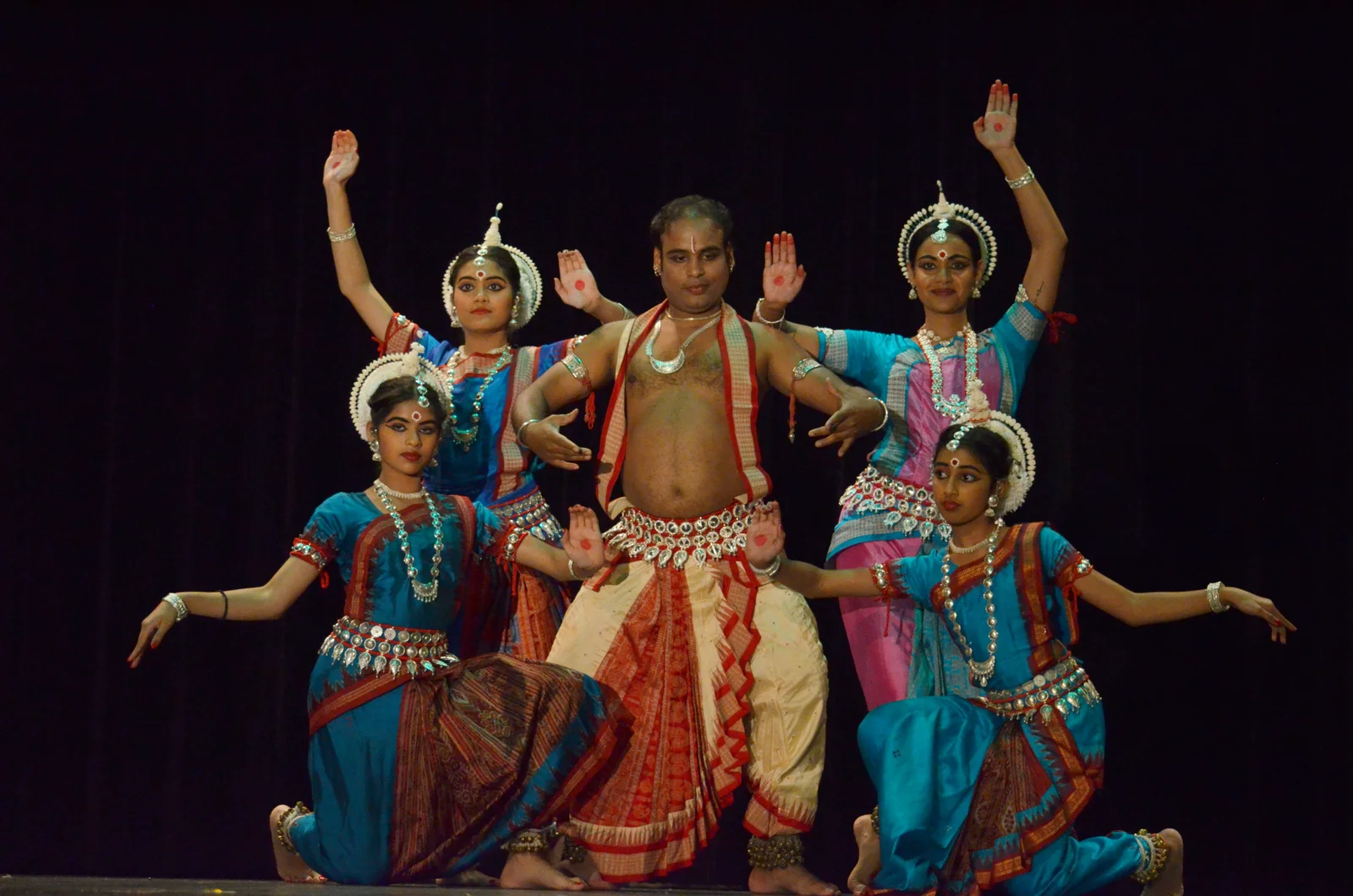 An Odissi dance performance with guru in a historical setting.