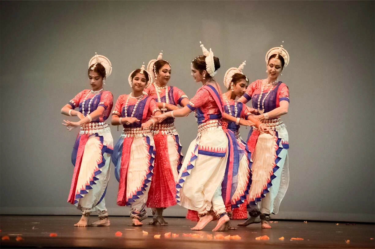 Odissi dance group performing with expressive hand gestures and intricate footwork