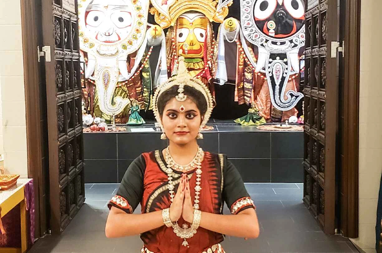Odissi dancer in traditional attire with intricate jewelry and vibrant costume